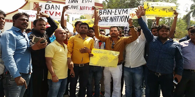 चुनाव आयोग के विरोध में अंबेडकर छात्रावास सभा के सदस्यों ने विवि गेट पर विरोध प्रदर्शन किया।